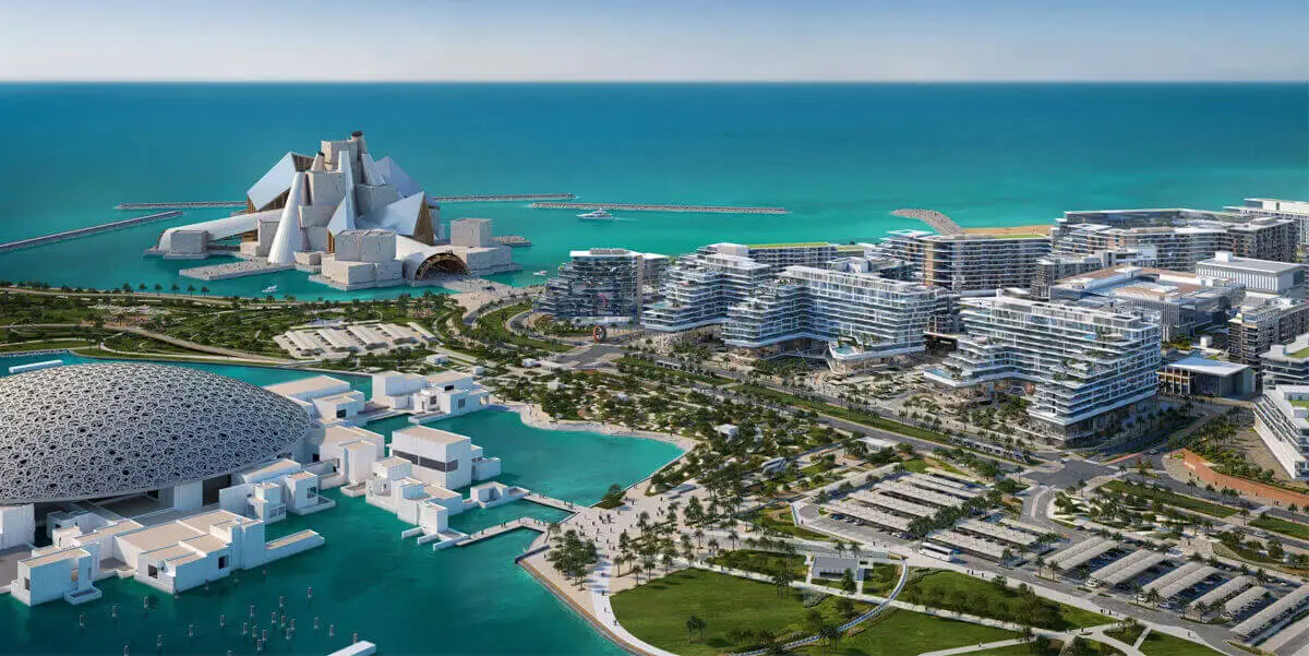 View of the Louvre Saadiyat Island Abu Dhabi and modern coastal development, featuring waterfront structures and lush green landscaping, reflecting an upscale urban environment.