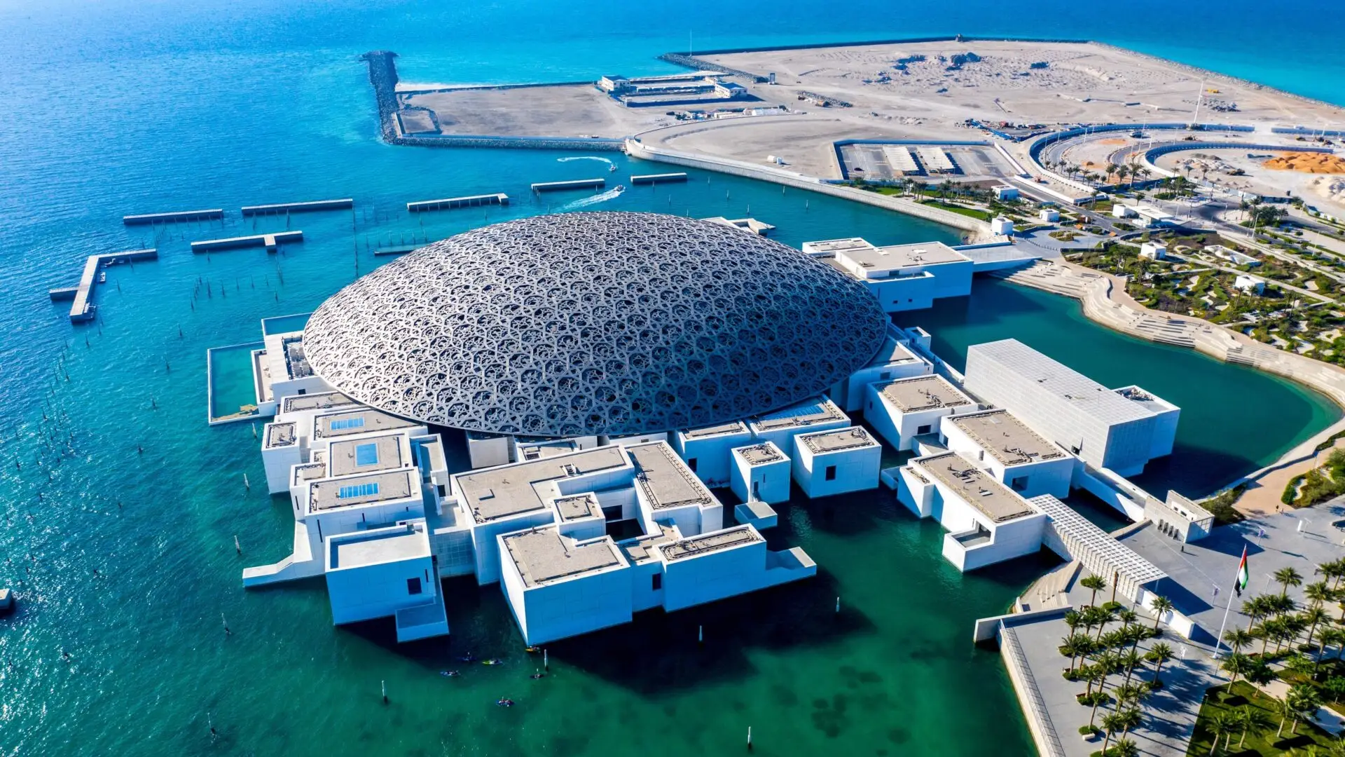 Saadiyat Island Aerial view of the Louvre Abu Dhabi, showcasing its iconic dome and surrounding waterfront structures.