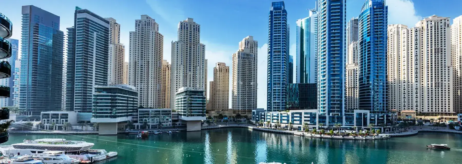 Investing in Dubai Scenic view of Dubai Marina at sunset, with modern skyscrapers reflecting on the water.