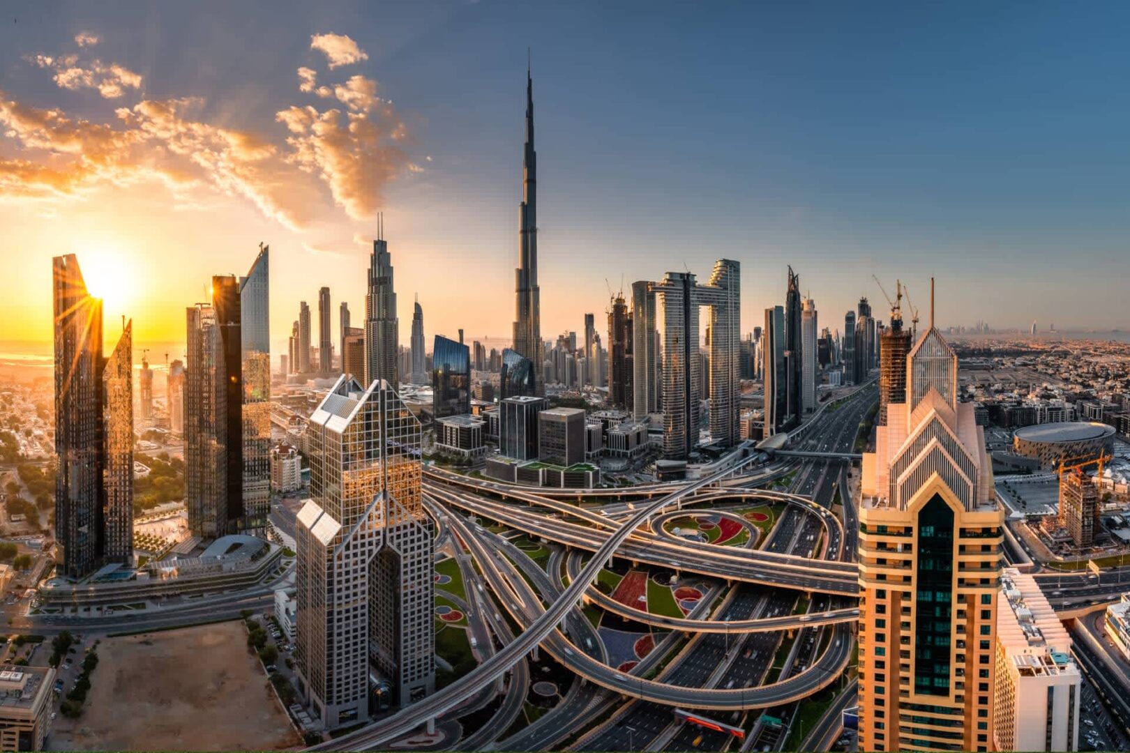 Dubai-property-market-stand A photo of Dubai and its skyline, with the Burj Khalifa and intricate highways visible in the image. The atmosphere is in the late afternoon