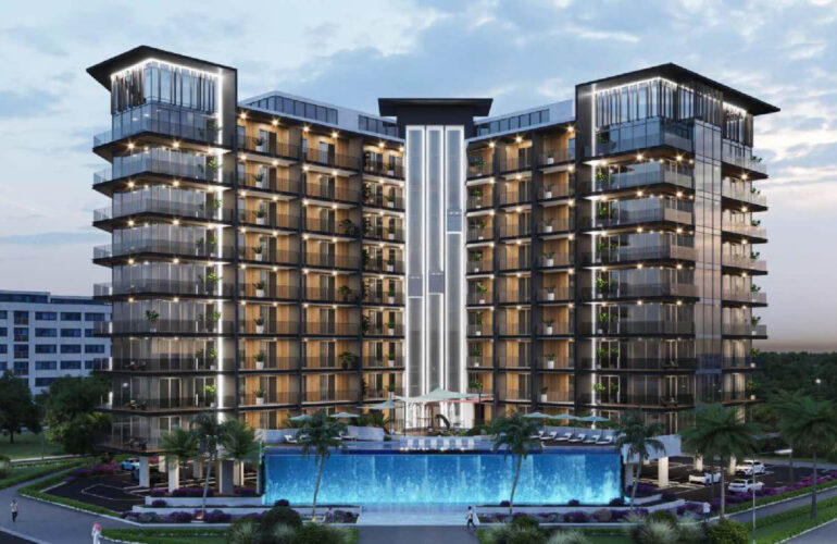 The photo is from the front of an apartment, which is silver, but the room is yellow, and there is an infinity pool in front of it, and there are green spaces next to that apartment.