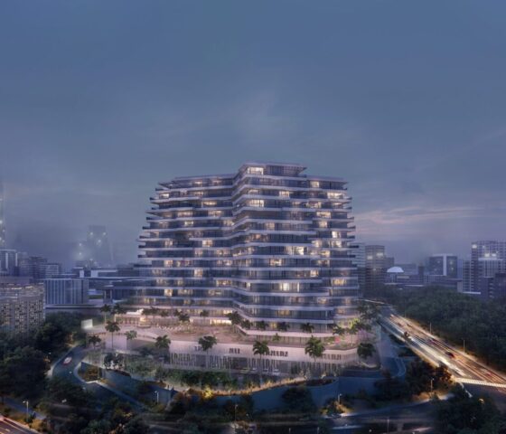 A distant view of Trinity Exterior-Night in Dubai, at night with cloudy skies and the apartment lights illuminating its beautiful exterior