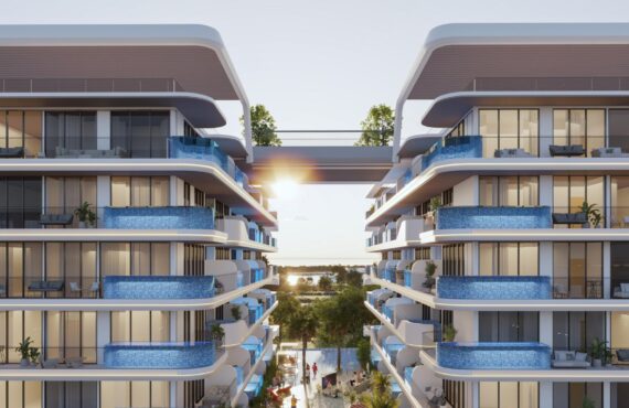 Front view of Samana Ocean Pearl 2 in Dubai, an apartment on top of a mountain or green hill, with a white and blue house. The photo was taken from the front of the apartment.