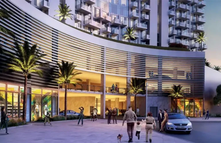 A modern building entrance in Dubai with curved architecture, an illuminated facade, and residents enjoying the evening.