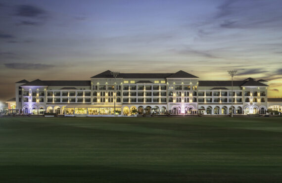 A luxurious hotel building at dusk with elegant lighting, part of Al Habtoor Polo Resort & Club Dubai.