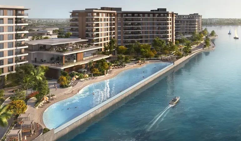 A scenic aerial view of the waterfront residences in Dubai, surrounded by lush greenery.