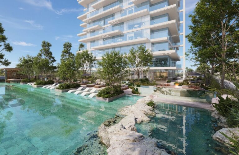 Crystal lagoon with landscaped greenery and outdoor seating areas at Ayaan Heights