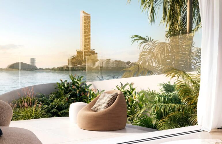 Scenic balcony lounge with view of Dubai Creek Tower surrounded by lush greenery.