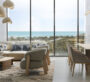 Stylish living room in Bayfront Marina Residences, Dubai, with panoramic floor-to-ceiling windows facing the sea.