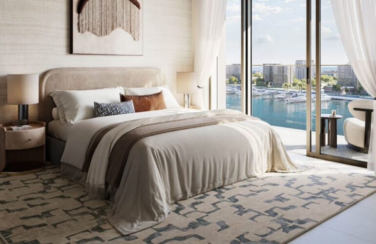 Comfortable bedroom at Baystar by Vida in Dubai, featuring large windows with views of the calm marina waters.