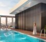 Elegant indoor pool area at Binghatti Twilight in Dubai with a woman enjoying the serene atmosphere.