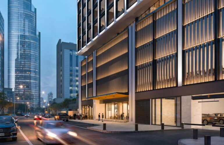 Street-level view of Binghatti Twilight’s entrance in Dubai with modern architecture and city lights.