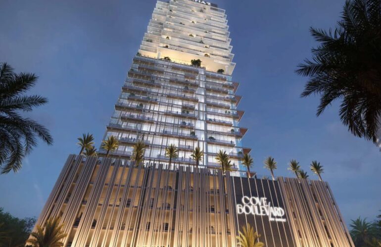 Illuminated tower exterior at night with palm trees in front