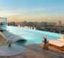 Rooftop infinity pool at Cove Edition 6, Dubai, offering panoramic views of the city skyline and a luxury sunbathing area.