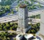 Two modern high-rise towers surrounded by greenery and roads