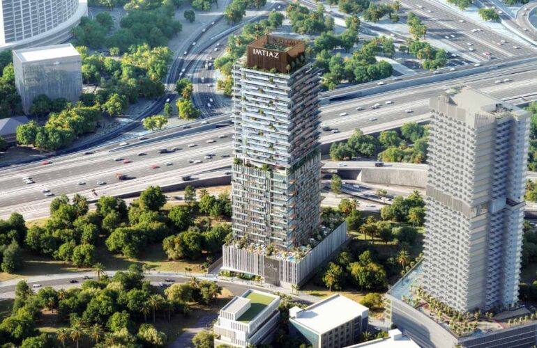 Two modern high-rise towers surrounded by greenery and roads