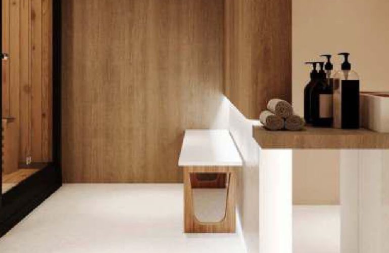 A sauna with white chairs and wooden walls and floor and a glass door