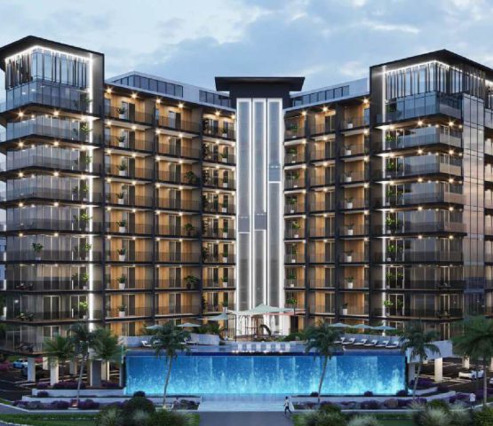 The photo is from the front of an apartment, which is silver, but the room is yellow, and there is an infinity pool in front of it, and there are green spaces next to that apartment.