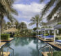 A stunning infinity pool surrounded by palm trees and luxurious cabanas at Al Habtoor Polo Resort & Club Dubai.