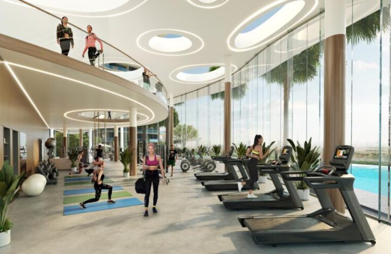 Fitness studio at Laguna Residence in Dubai, with treadmills arranged in rows next to large windows, offering a view of the outdoor pool