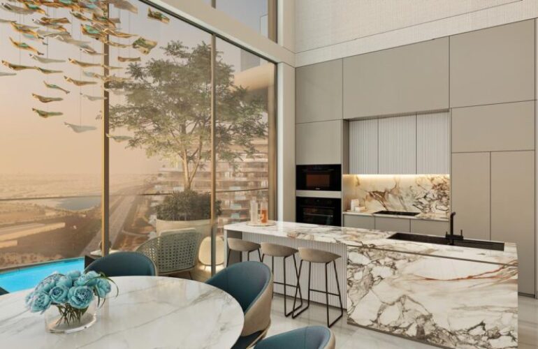 Kitchen at Laguna Residence in Dubai, featuring a kitchen island with a dining table on the other side. A large window beside the kitchen offers a view of the outside.