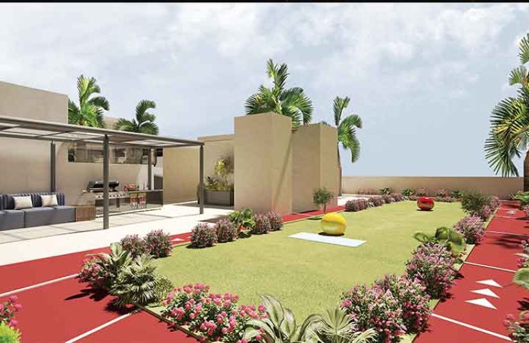 A modern rooftop garden featuring a lush green lawn, a red jogging track, and beautifully landscaped flower beds with vibrant plants. The area includes an elegant outdoor seating space with a shaded pergola, comfortable sofas, and a built-in barbecue station. Palm trees and tropical plants surround the space, creating a serene and stylish atmosphere. The open sky and natural sunlight enhance the inviting and relaxing ambiance.