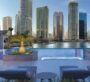 Elevated rooftop pool with luxury lounge chairs overlooking the Dubai skyline at ME DO RE Business tower.