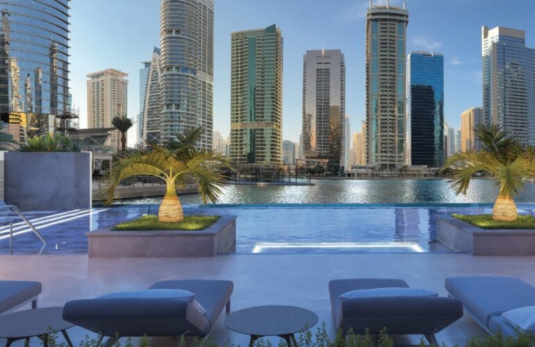 Elevated rooftop pool with luxury lounge chairs overlooking the Dubai skyline at ME DO RE Business tower.