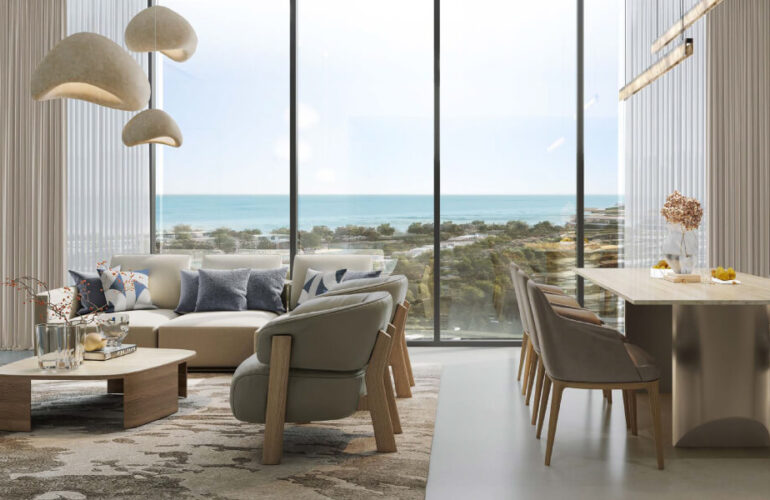 The living room in Pierside Marina Residences features a dining table next to the wall. There are also large windows offering a beautiful view of a green park.