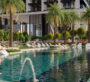 Infinity-edge leisure pool with sunbeds and palm trees at Sobha Central