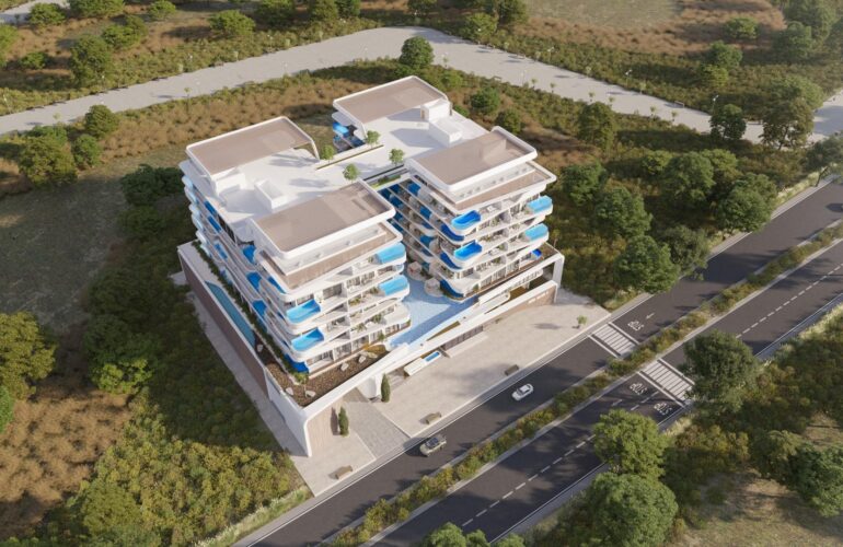 An apartment on top of a mountain or green hill, featuring a white and blue house at the front view. SAMANA Ocean Pearl Dubai.