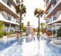 Pool at SAMANA Ocean Pearl in Dubai, surrounded by apartments with palm trees planted around the pool.