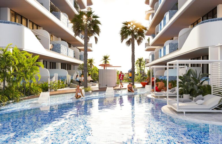 Pool at SAMANA Ocean Pearl in Dubai, surrounded by apartments with palm trees planted around the pool.