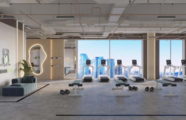 The gym at SAMANA Park Meadows in Dubai, with large windows and an outside view. Treadmills are placed by the windows, and yoga mats are in other areas