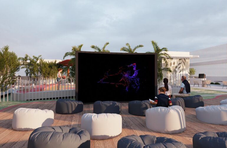 Kids play area at SAMANA Park Meadows in Dubai, featuring a large TV with small sofas arranged around it. The area is outdoors.