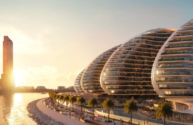 Sunset view of organically shaped buildings curving along the waterfront promenade.