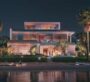 A photo of the front view of a large villa at The Acres Estates in Dubailand, taken at night. In front of the villa, there is a lake.