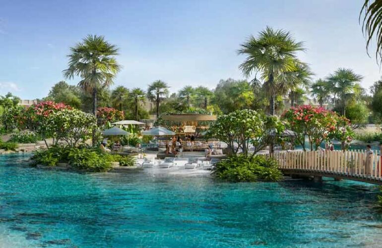 A photo of the lagoon at The Acres Estates at Dubailand Villas, featuring green space with beautiful trees and plants surrounding the water.