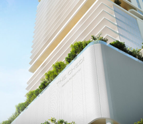 A view of The Chedi Private Residences in Dubai taken from below. Plants are visible at the base of the apartment, and the building extends upwards. The weather is sunny
