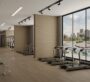 A spacious gym at Trinity - Gym in Dubai, featuring multiple treadmills arranged side by side. In front of them, a large window offers a view of the outdoors. Part of Dubai’s luxury real estate