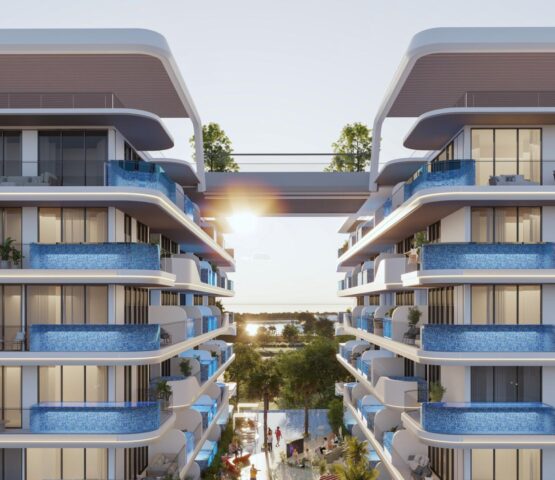 Front view of Samana Ocean Pearl 2 in Dubai, an apartment on top of a mountain or green hill, with a white and blue house. The photo was taken from the front of the apartment.