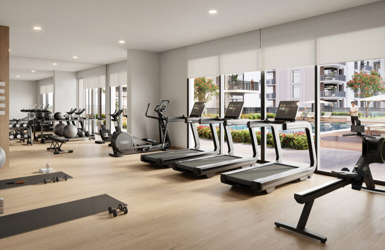 A gym where treadmills are arranged facing large windows